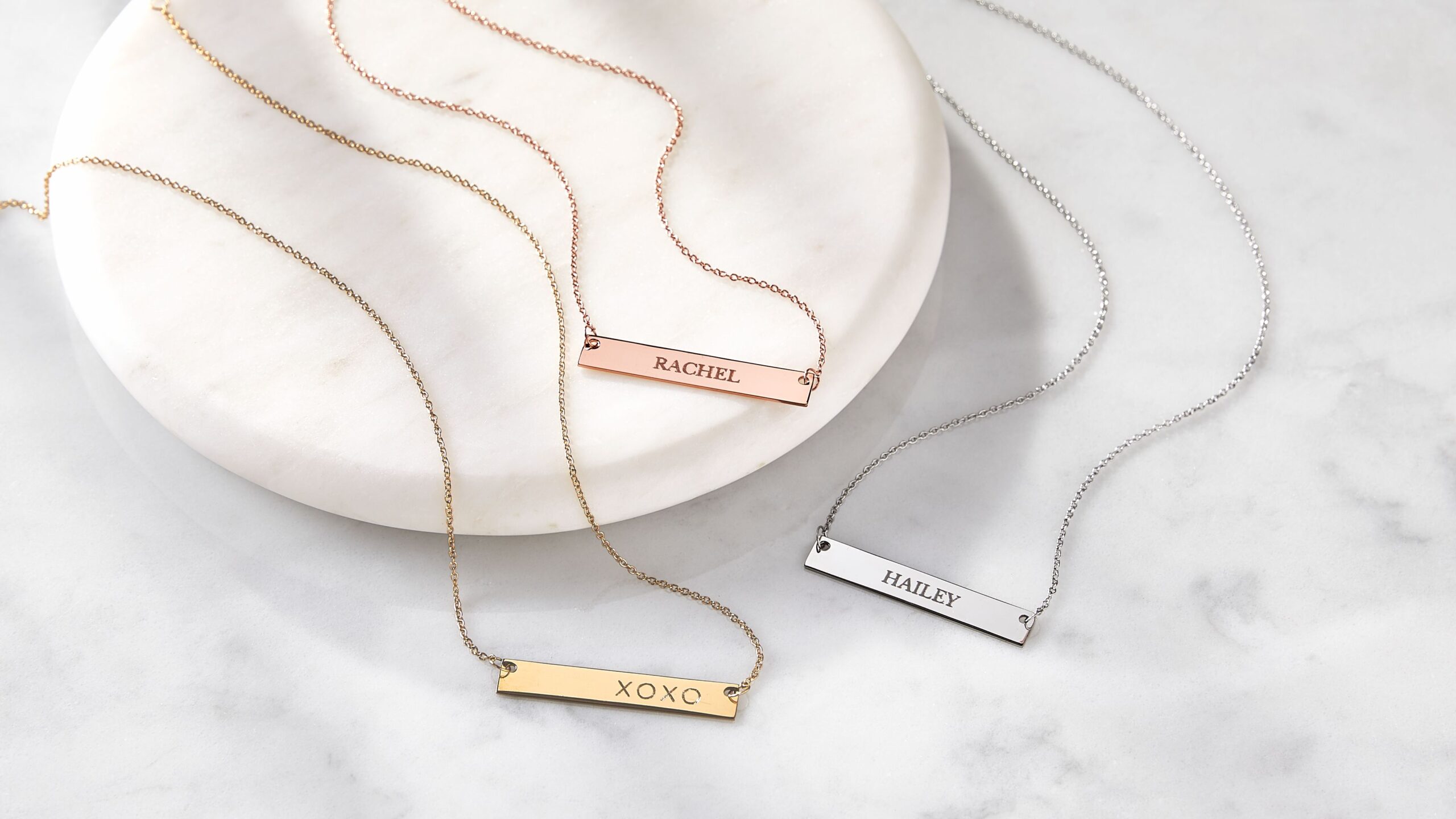 three engraved necklaces in different metals