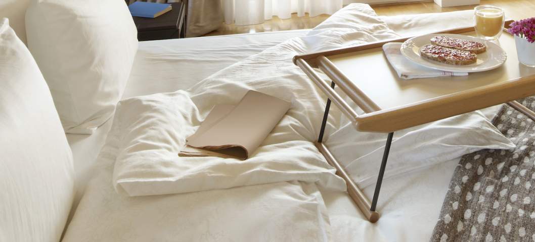 wide angle shot of a comfortable bedroom with breakfast in bed