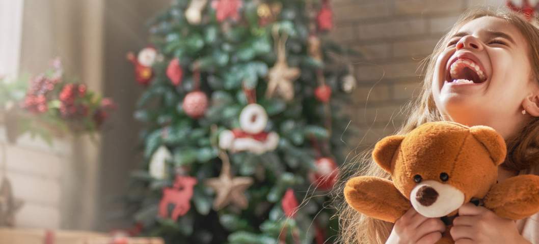 A girl opens her Christmas Eve present as a family Christmas tradition