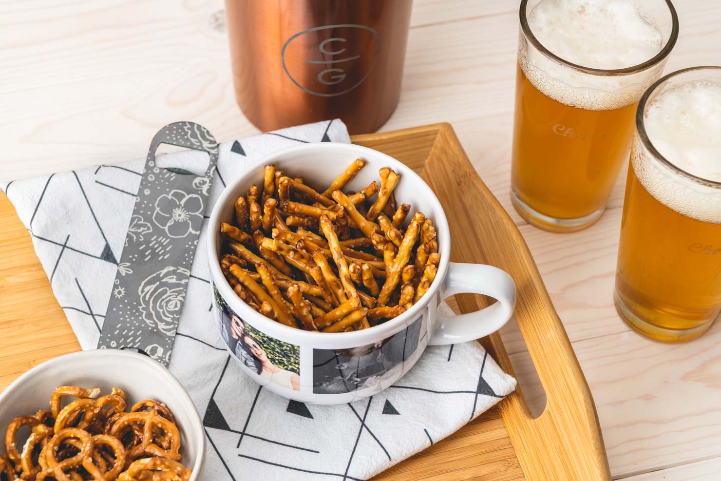 mug with pretzels in it next to beers