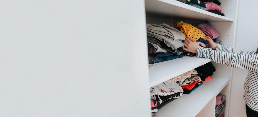 girl putting clothes away.