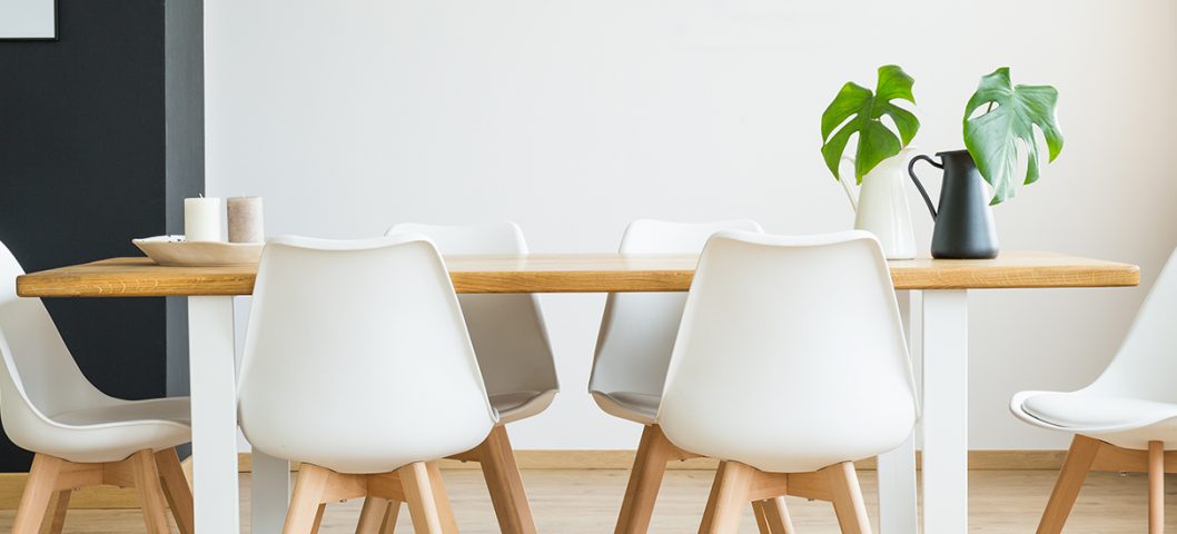 White dining room with plant.