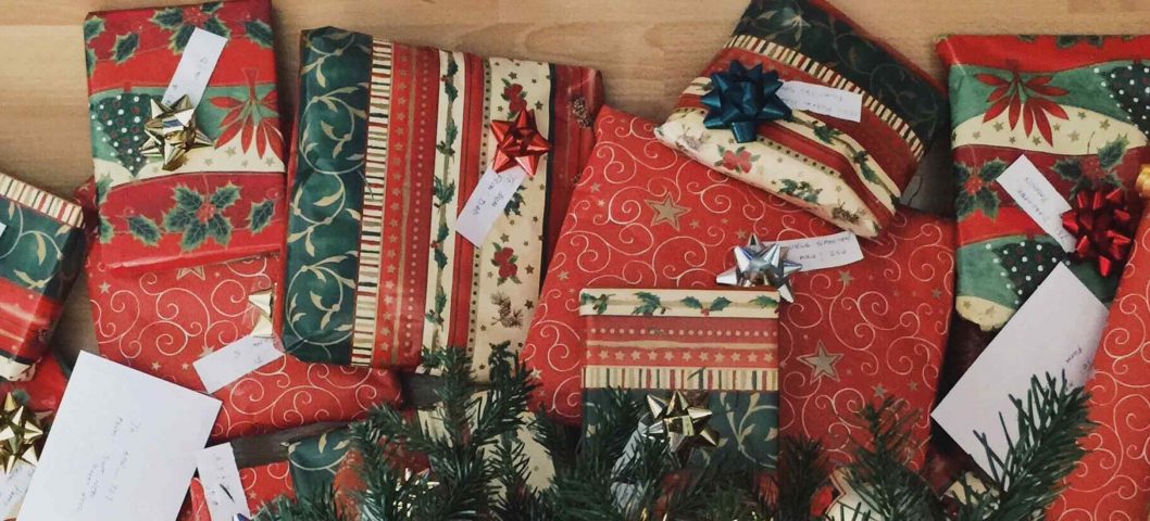 Pile of christmas gifts under tree.