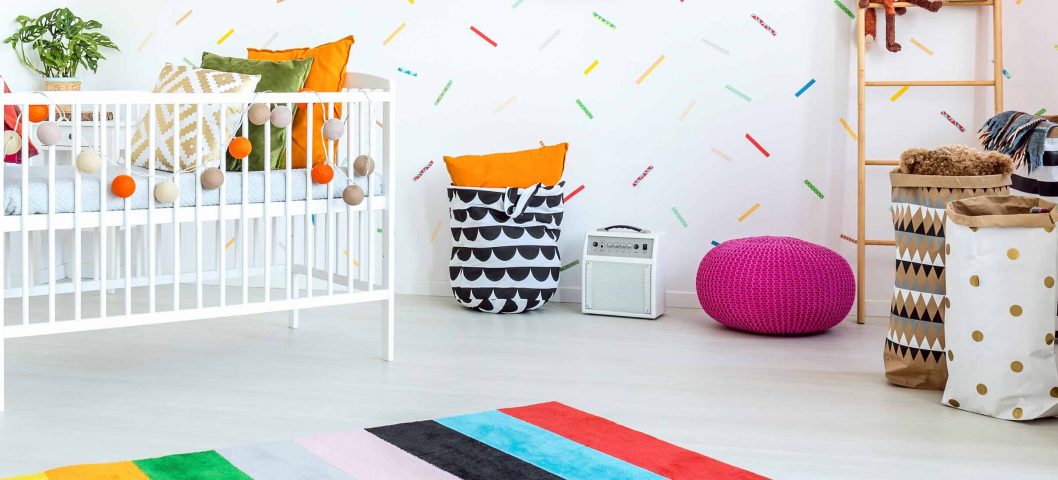 Nursery room with crib, dresser, and canvas baskets.