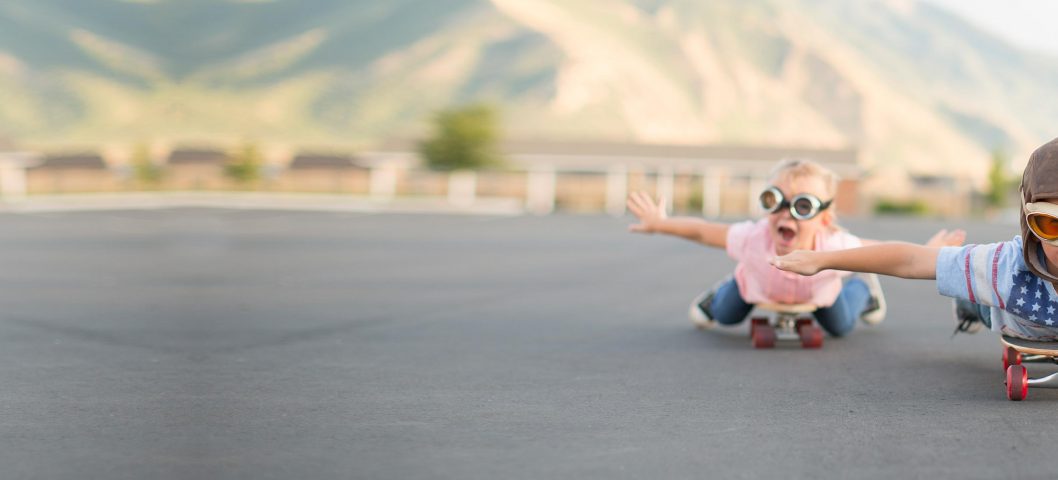 Boy and girl smiling on skateboards.