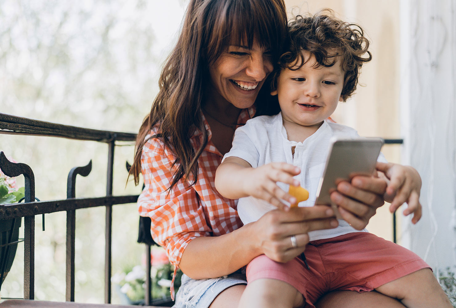 Mom and son smiling looking at phone.
