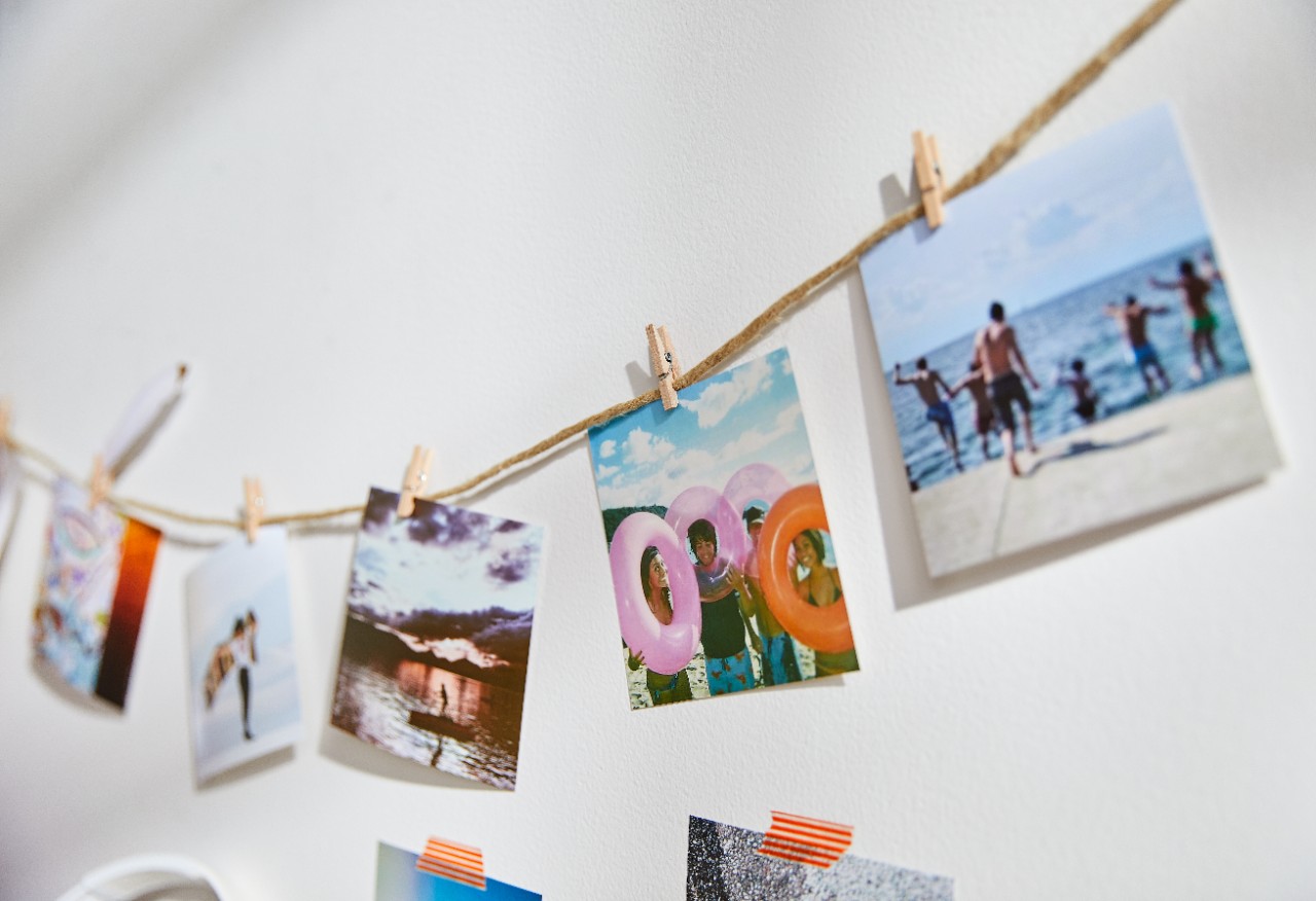 shutterfly prints hung on a string with small clothes pins