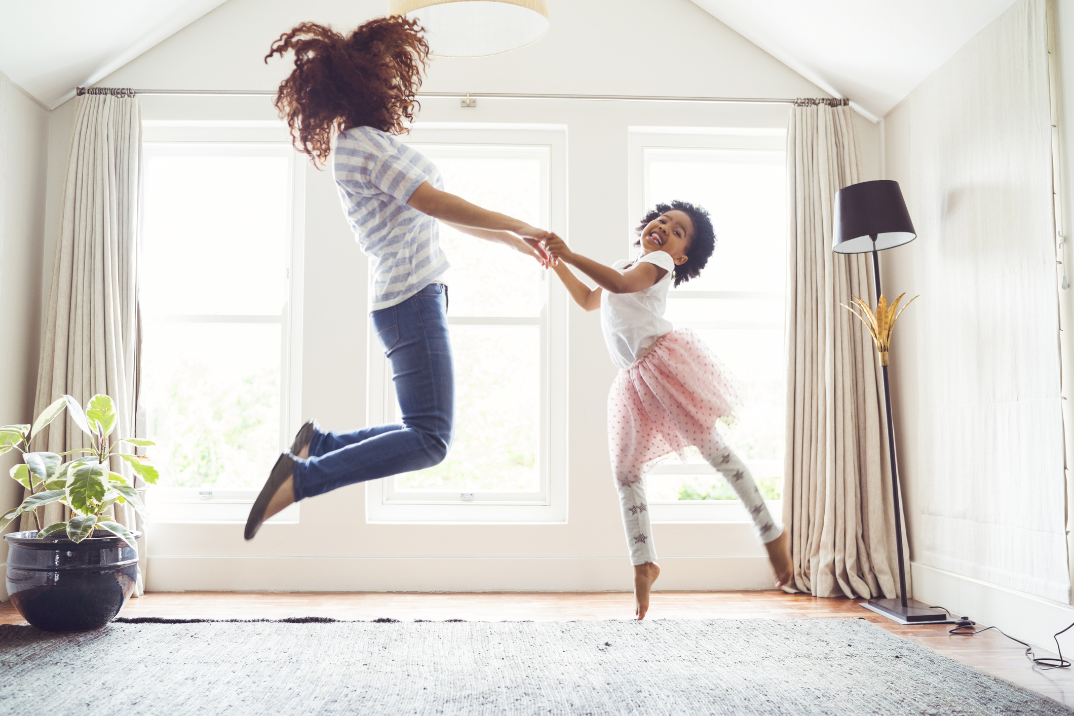 mother and child jumping and dancing at home
