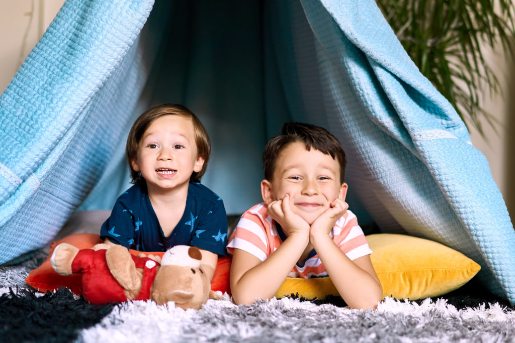 little kids in fort at home for a staycation