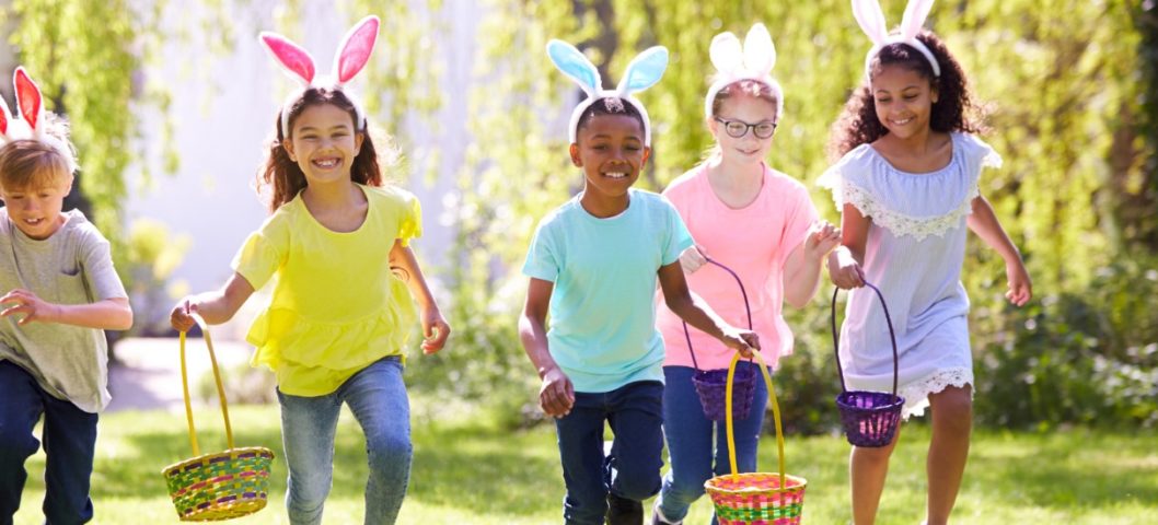 Portrait Of Five Children Wearing Bunny Ears On Easter Egg Hunt In Garden