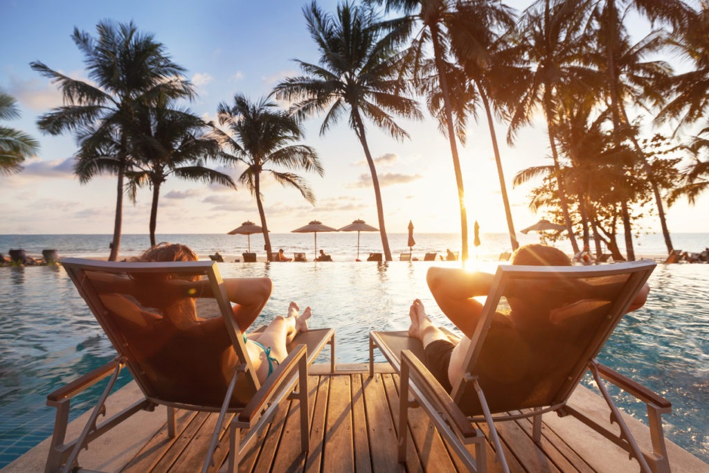 Weekend getaway ideas along the pool side watching the sun set between palm trees