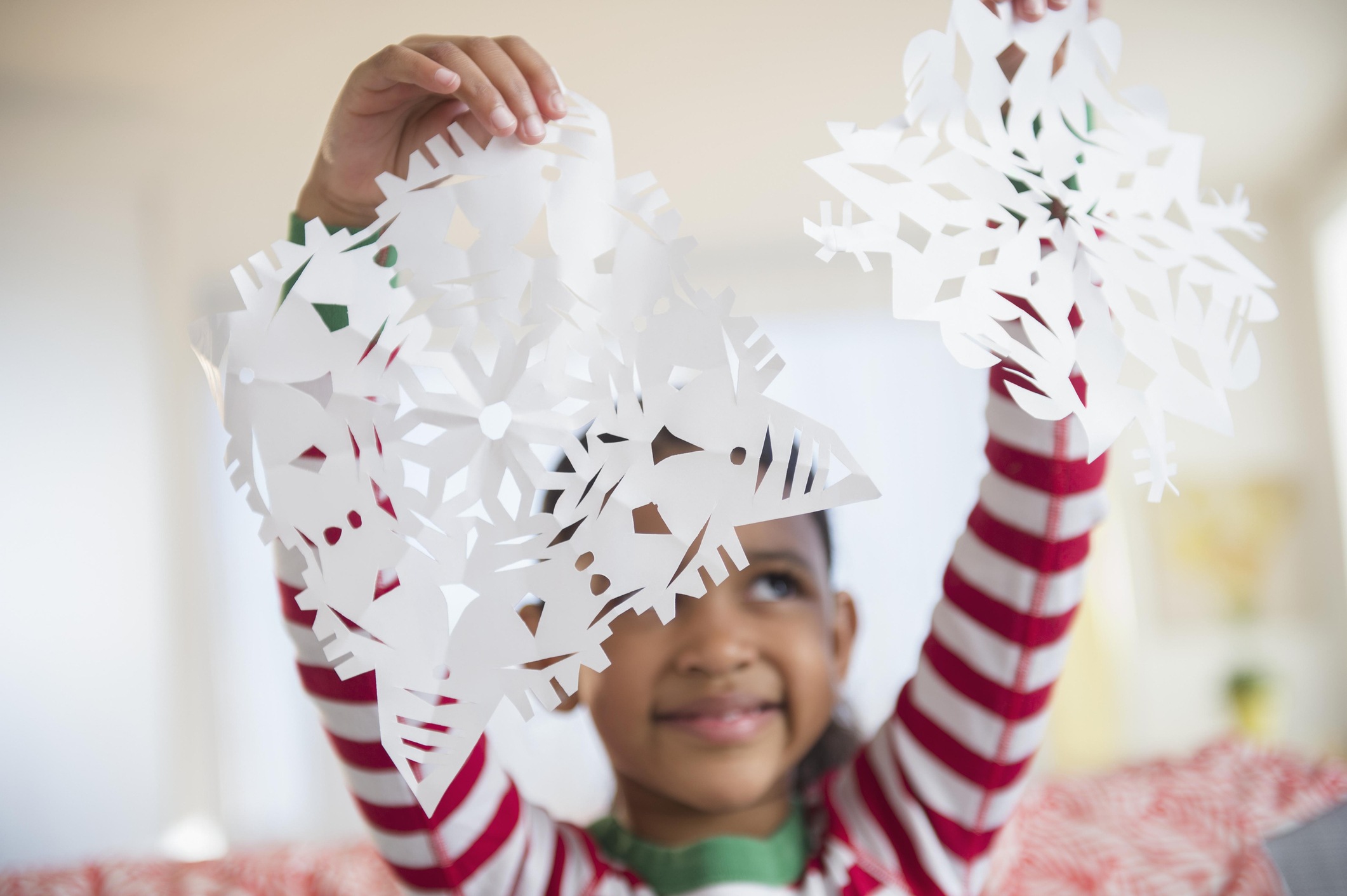Girl holding paper snowflakes