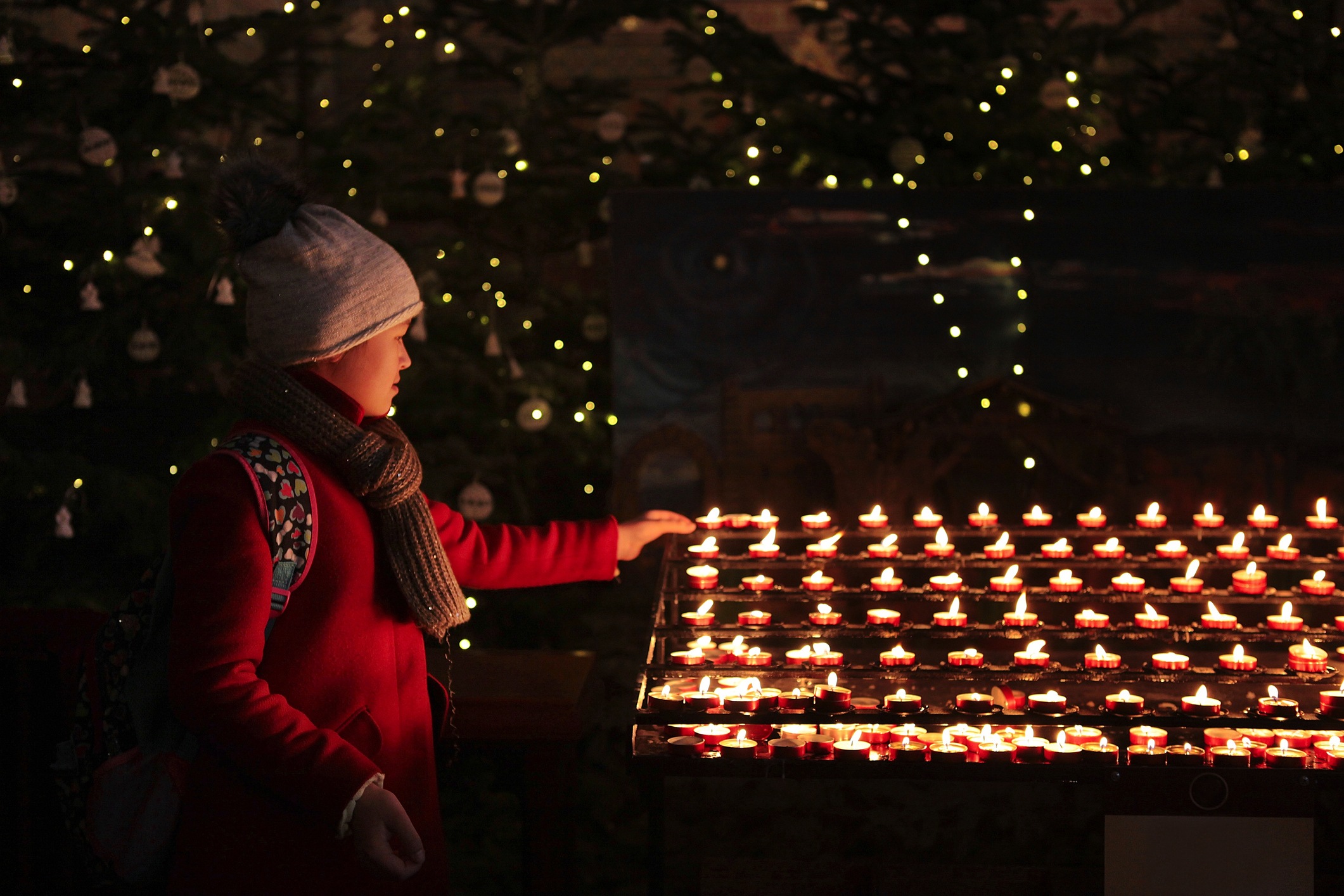 Young girl lit candle in the church on christmas day