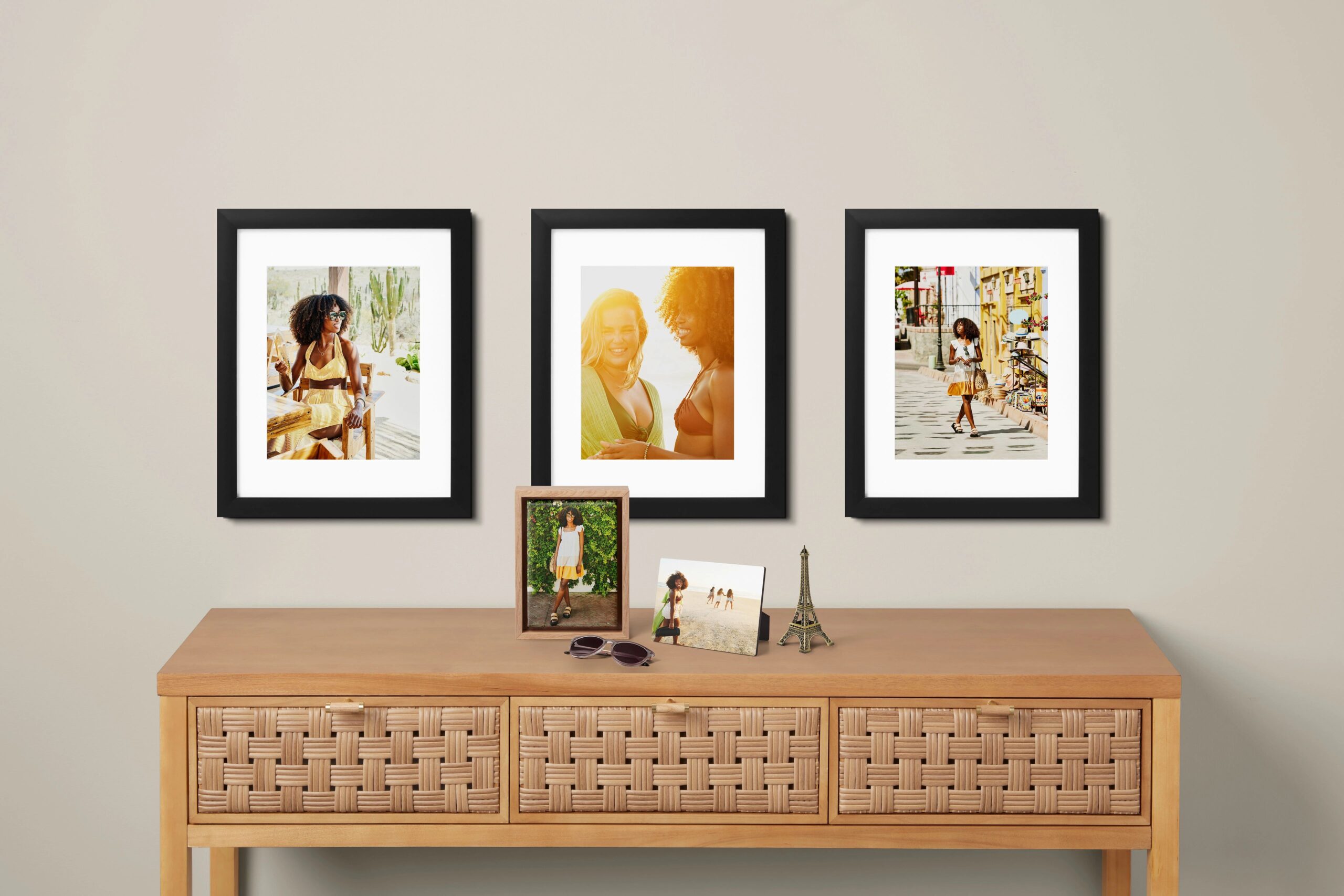 three 16x20 framed prints hanging on a wall above tabletop prints on a mantle