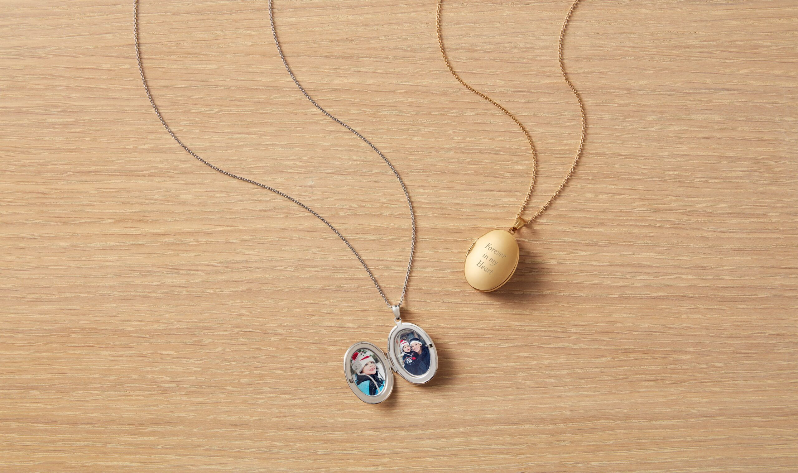 two locket necklaces with one open featuring a photo and the other closed