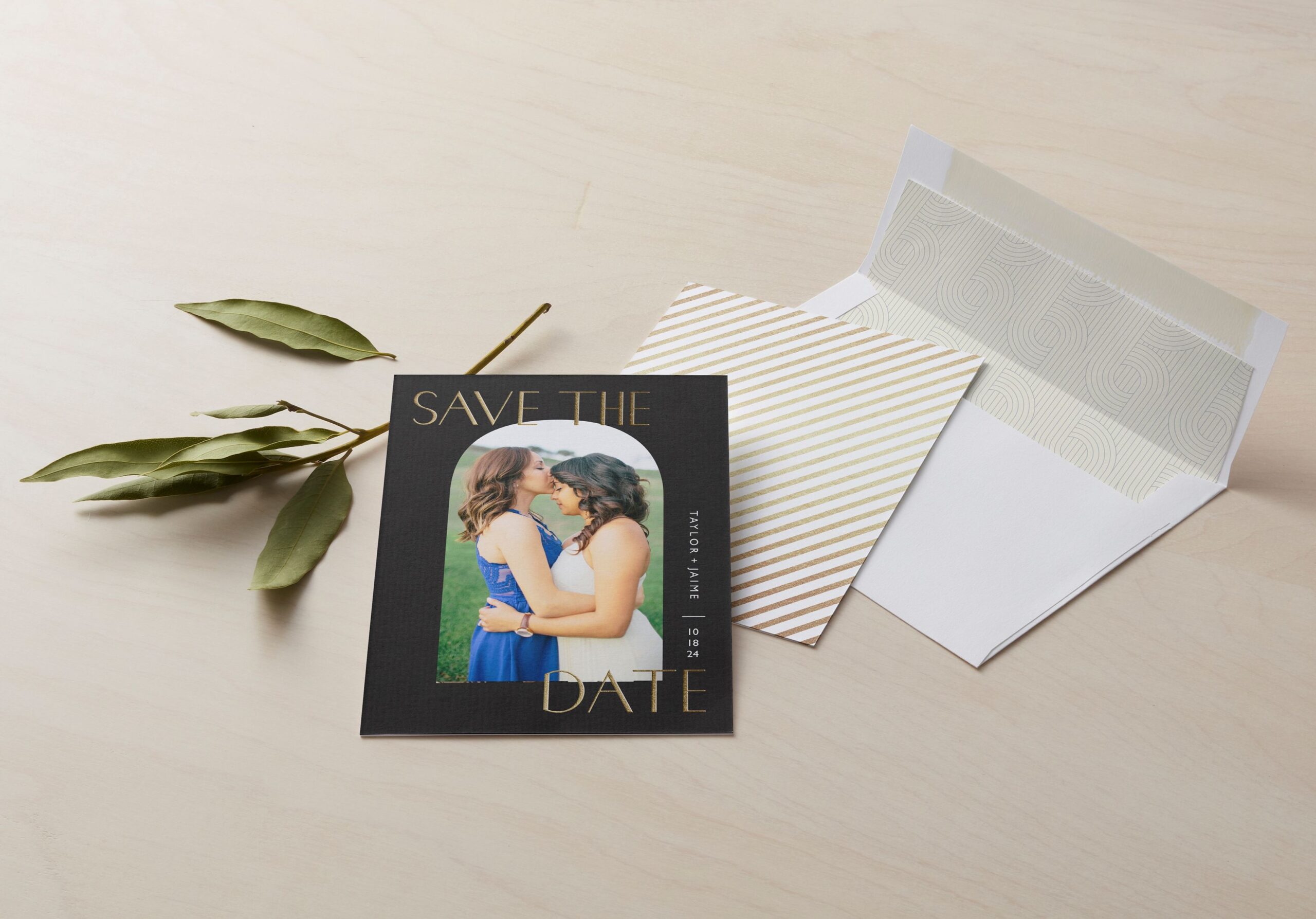 save the date card with a photo of a couple embracing and an envelope next to the card