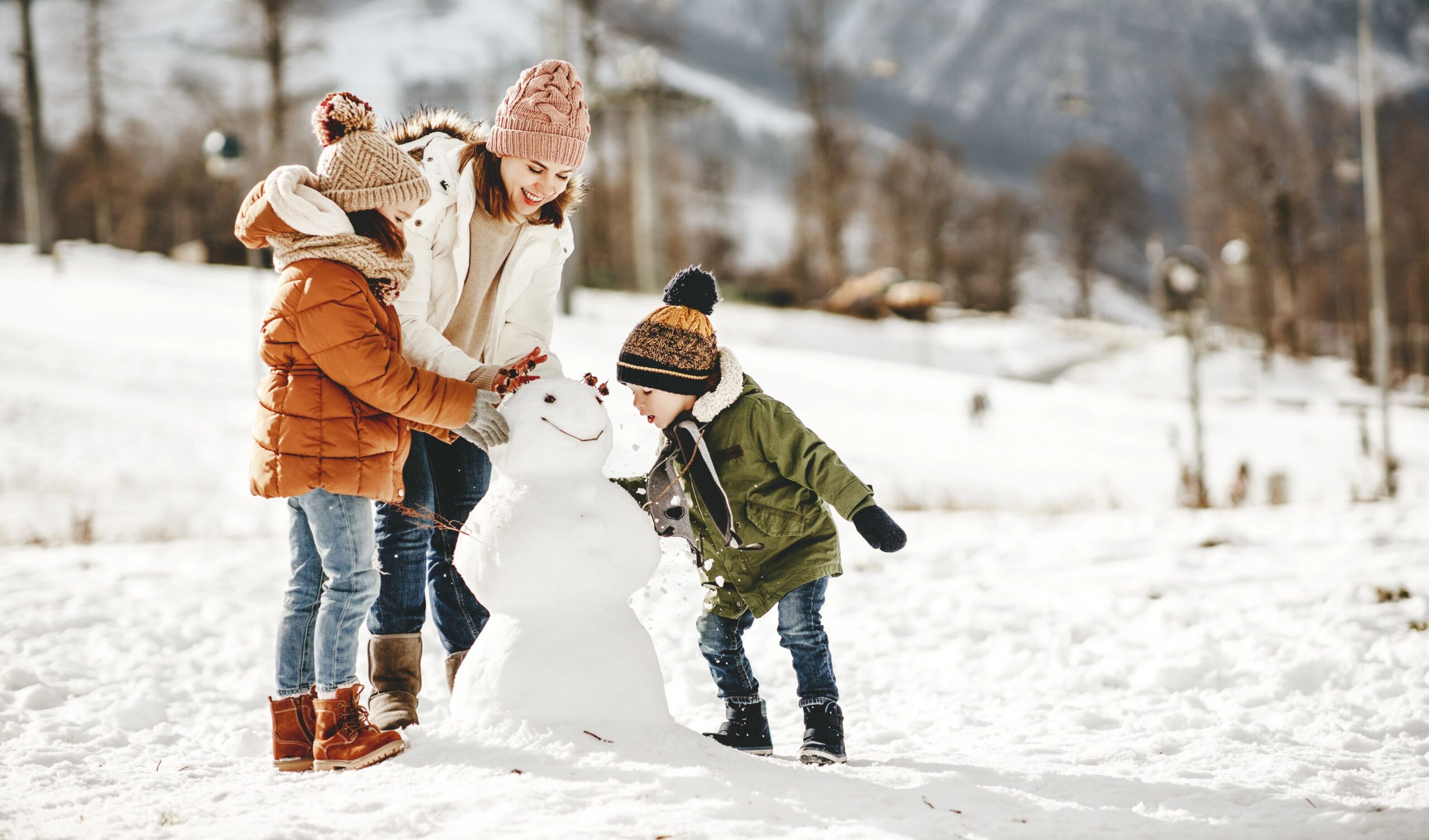 family outside building a snowman