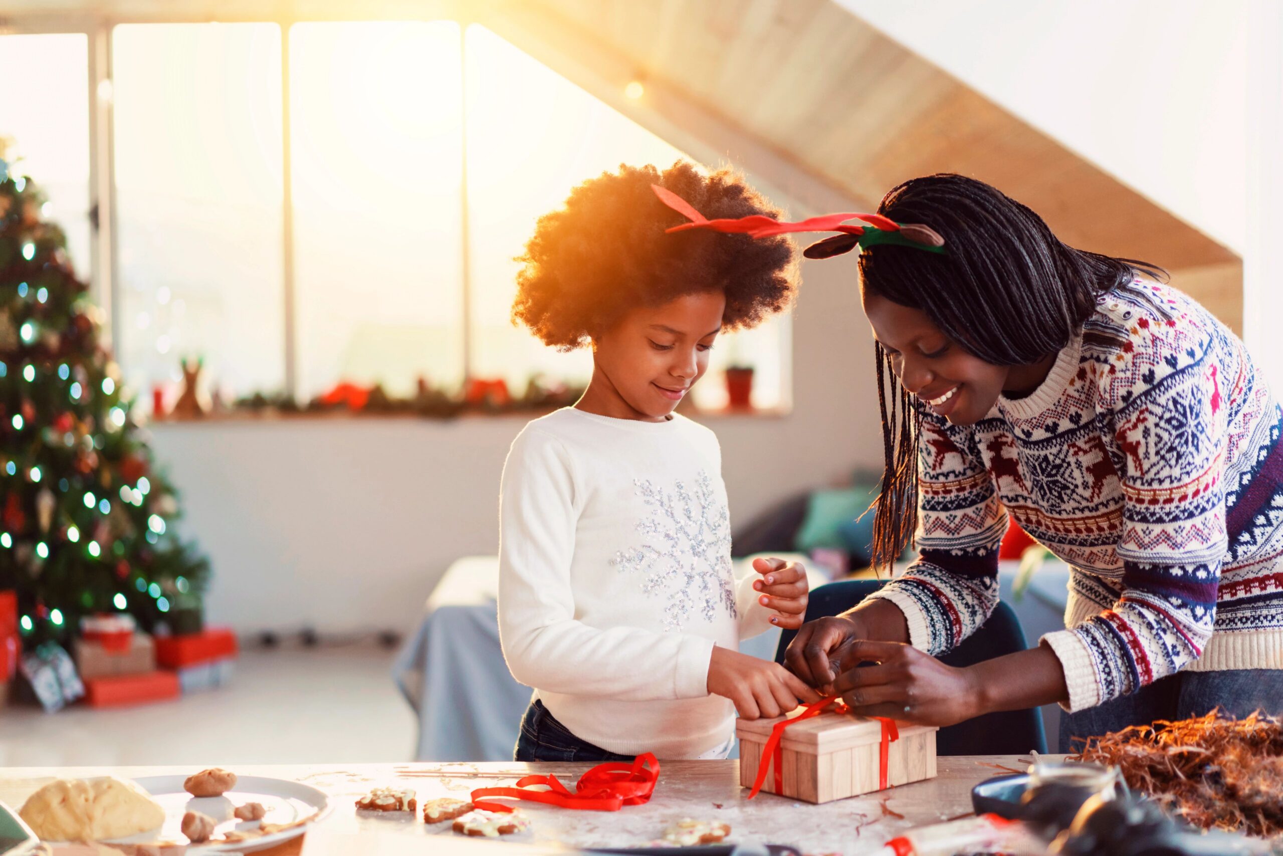 mom and daughter wrapping christmas gifts together
