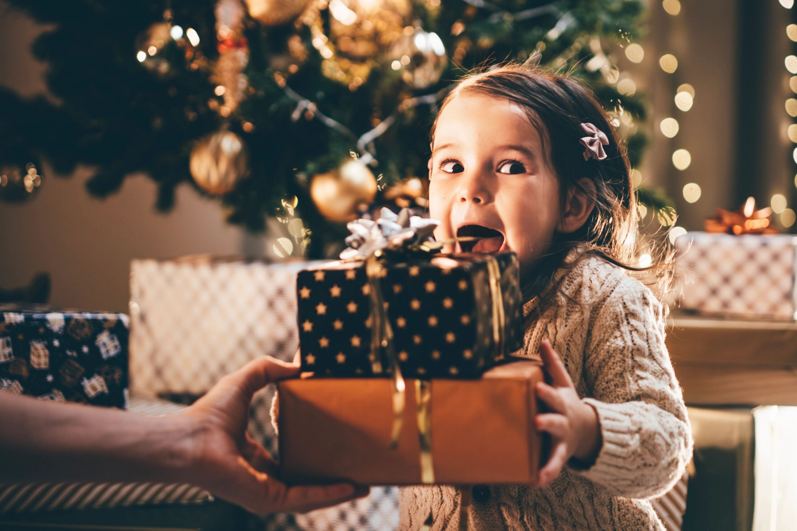 young girl excited when opening christmas gifts