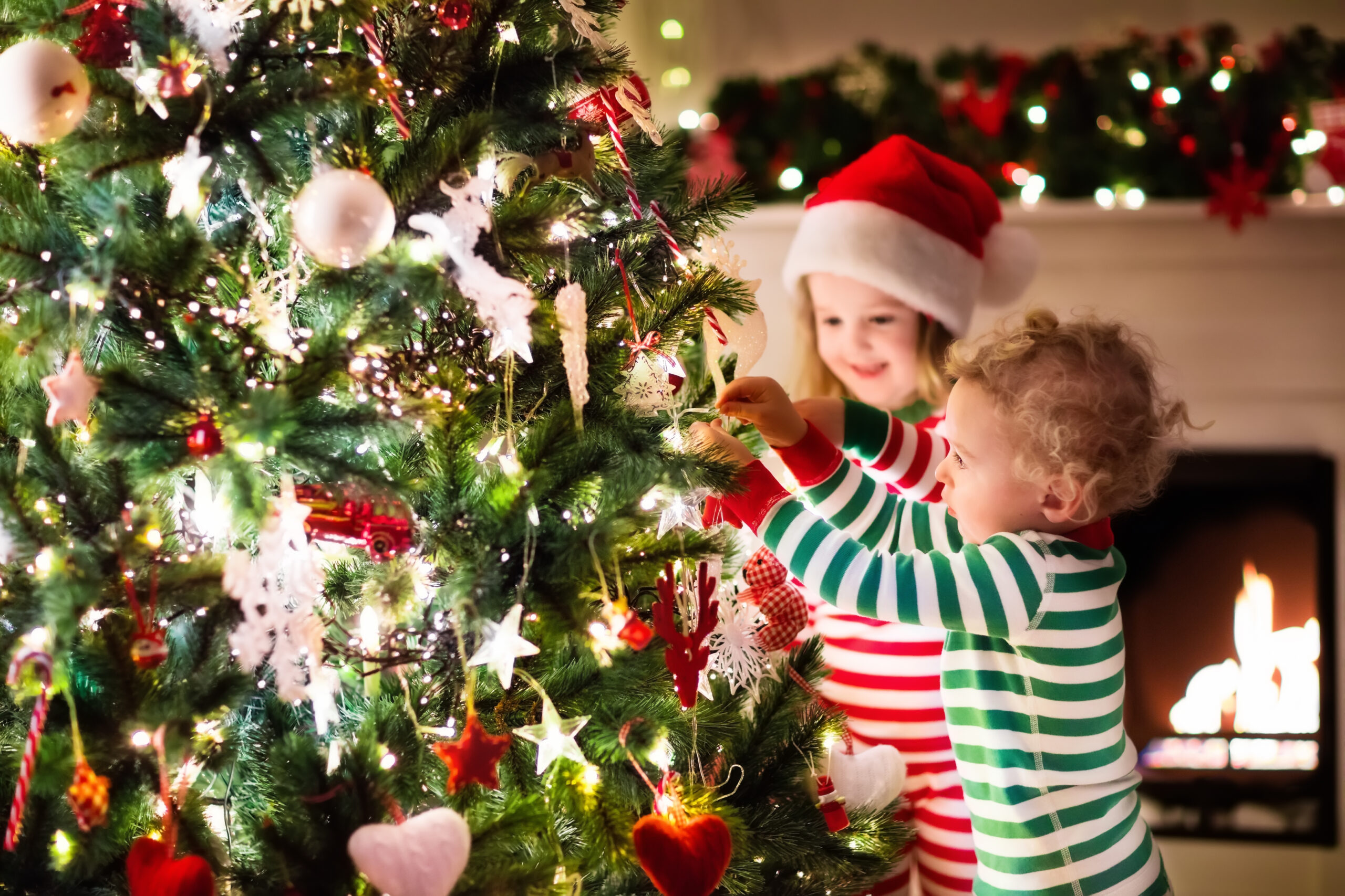 two kids decorating christmas tree