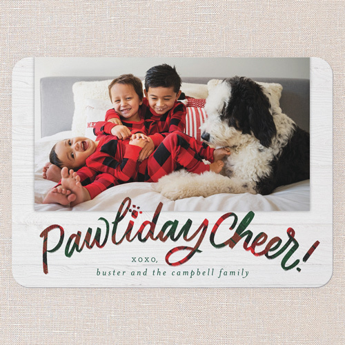 christmas card with photo of kids with matching pajams on a bed with their dog