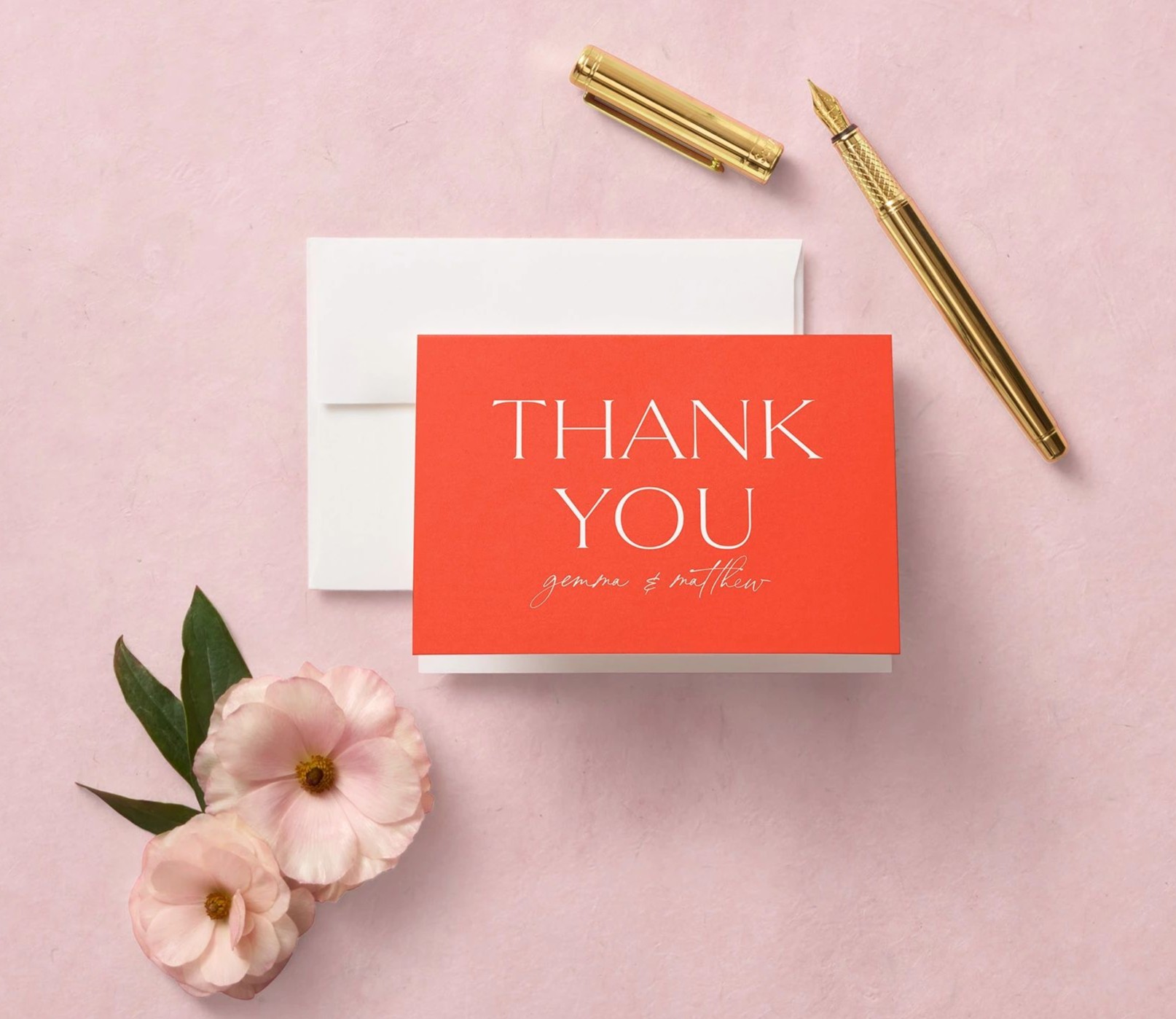 orange wedding thank you card on a pink flatlay
