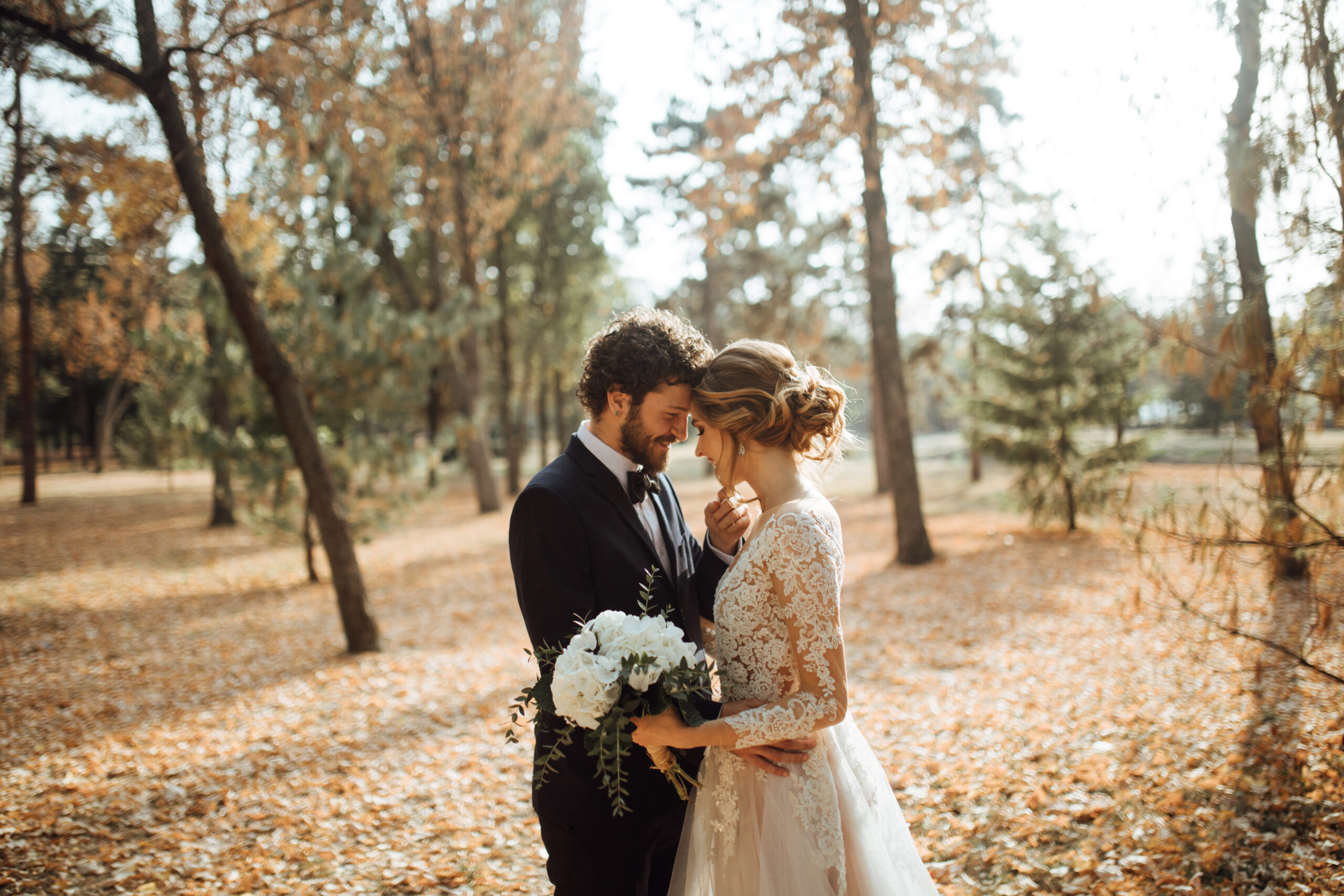 bride and groom embracing in a fall setting