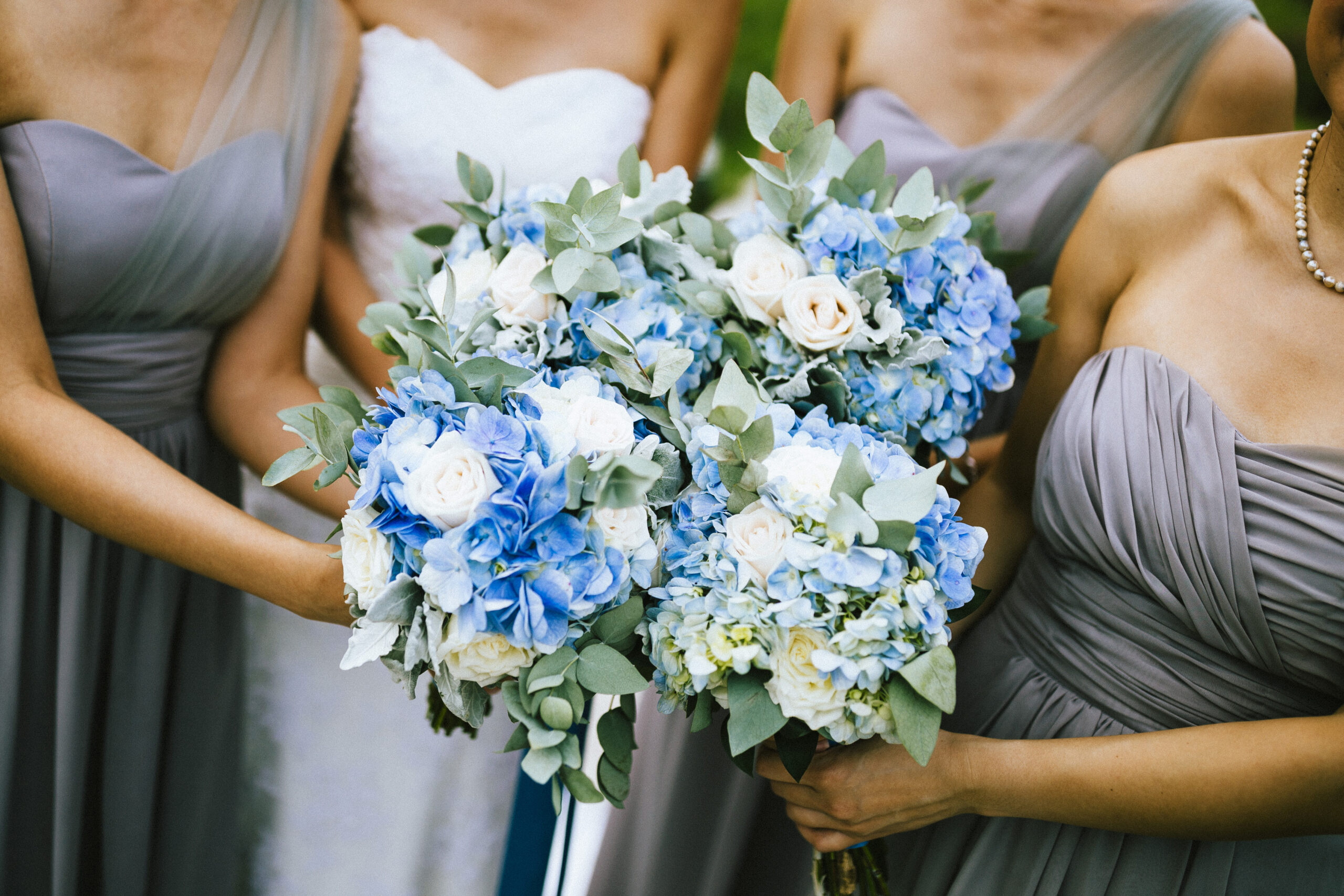 bride and bridesmaids holding blue flowers