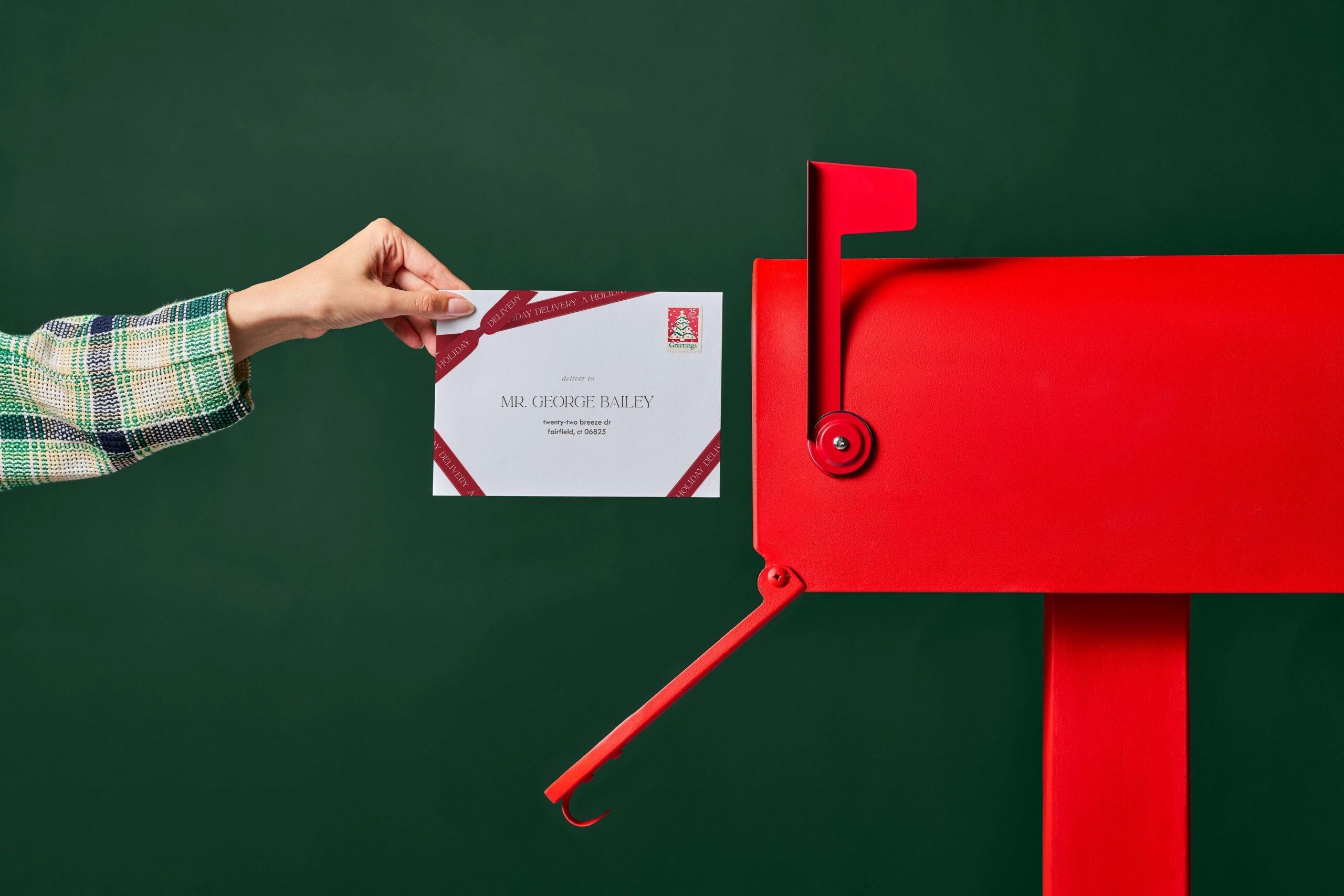 putting a christmas card in a mailbox