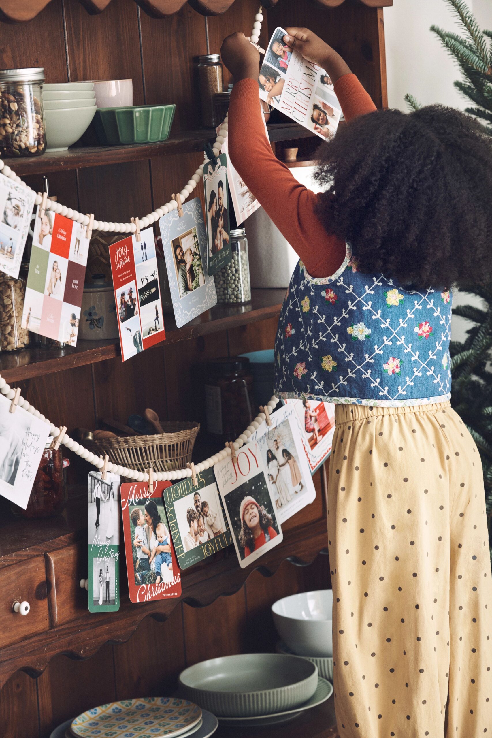 young girl handing christmas cards on a garland