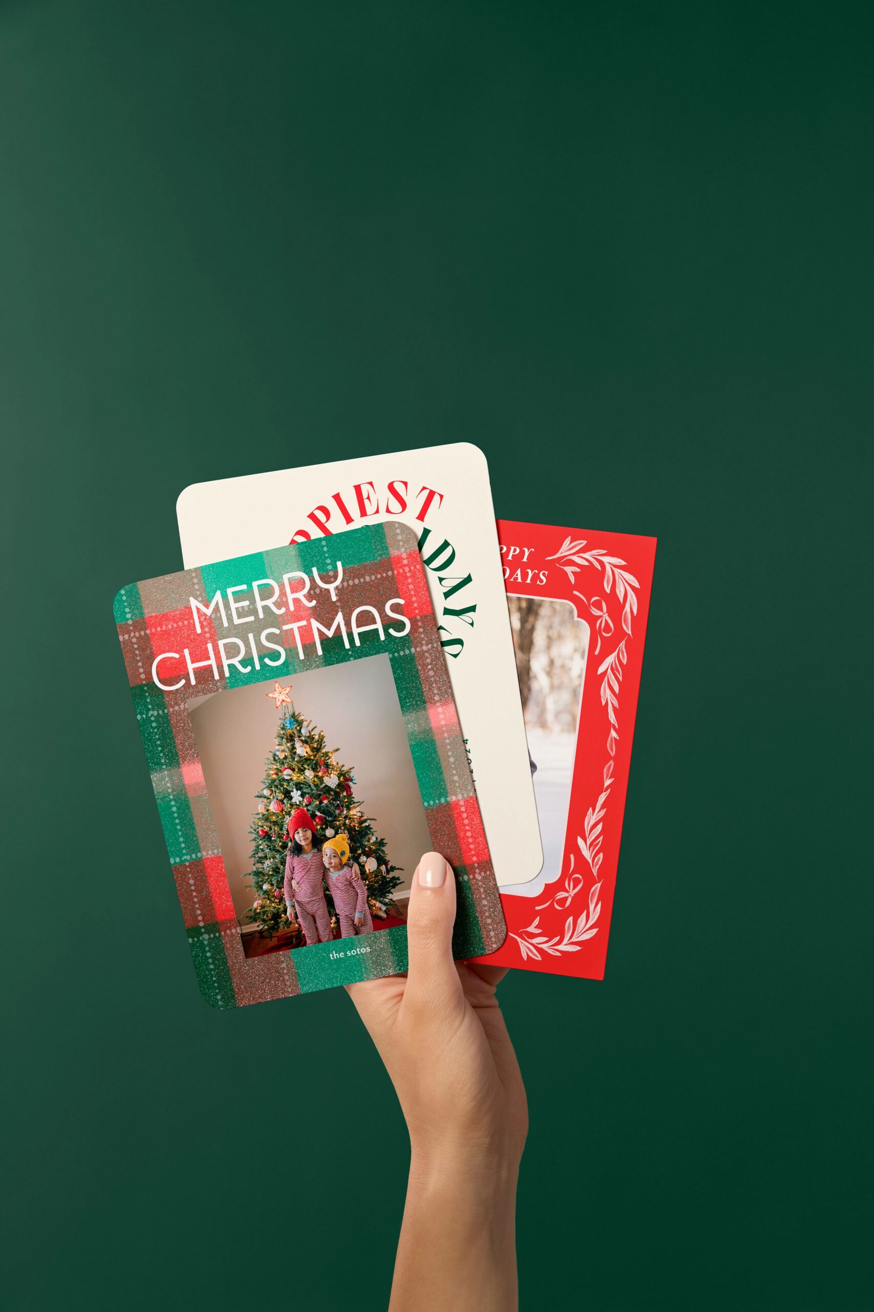 hand holding three christmas cards