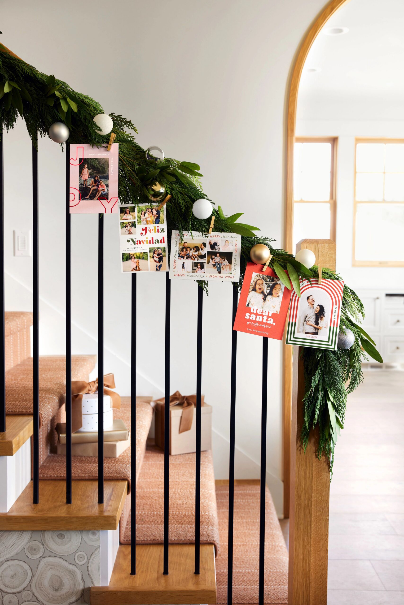 christmas cards displayed on garland on staircase