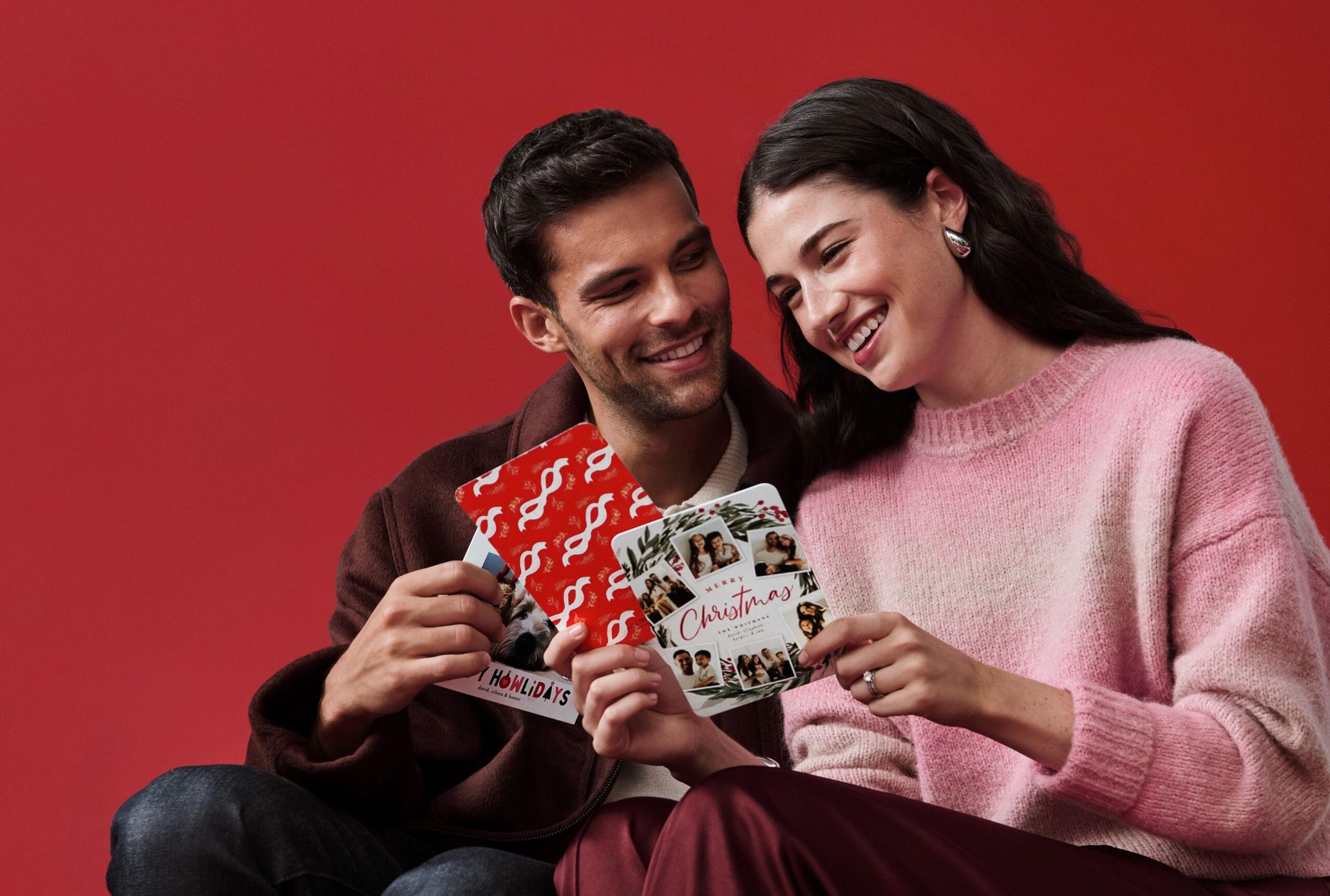 a man and woman looking at christmas cards