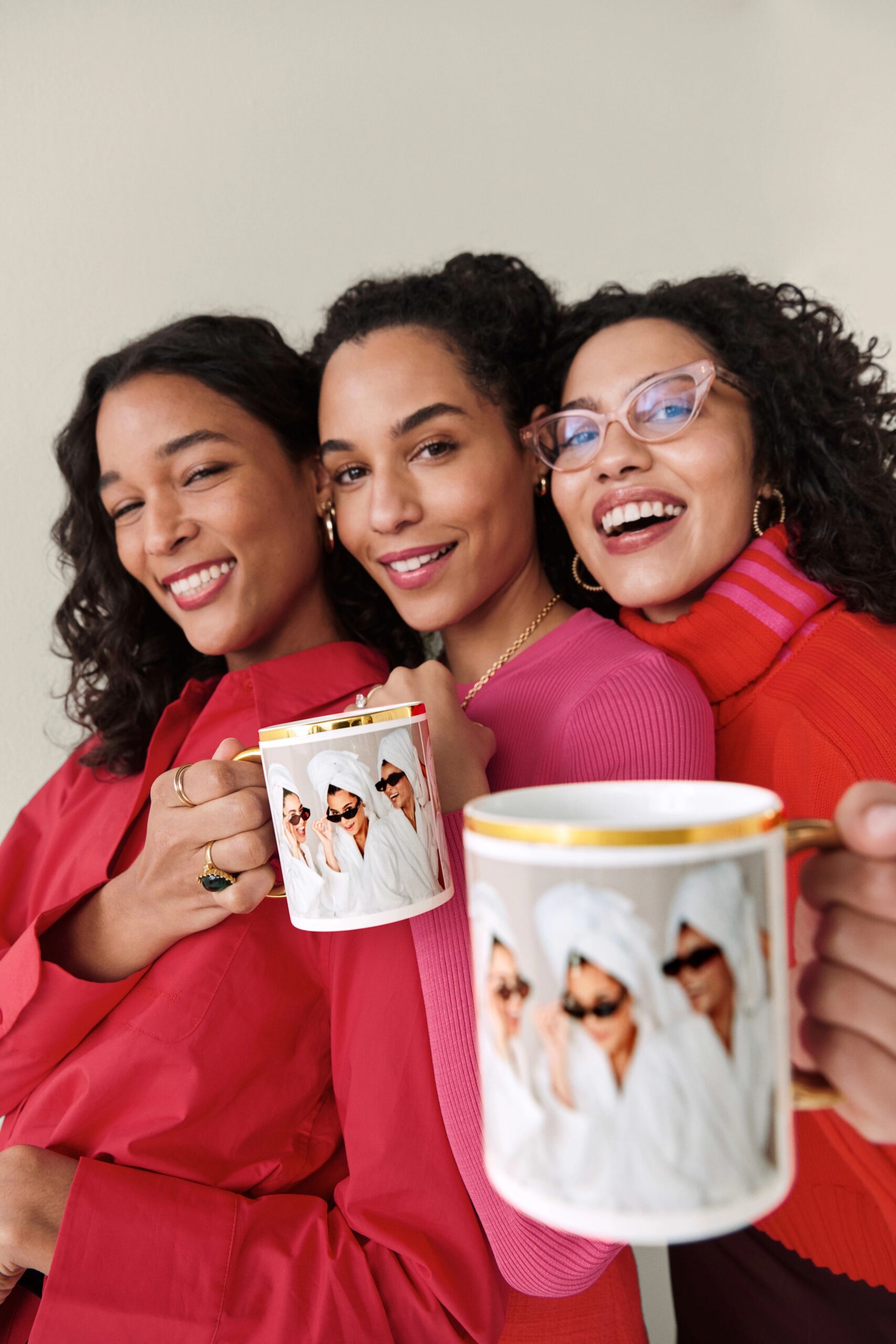 three women holding photo mugs