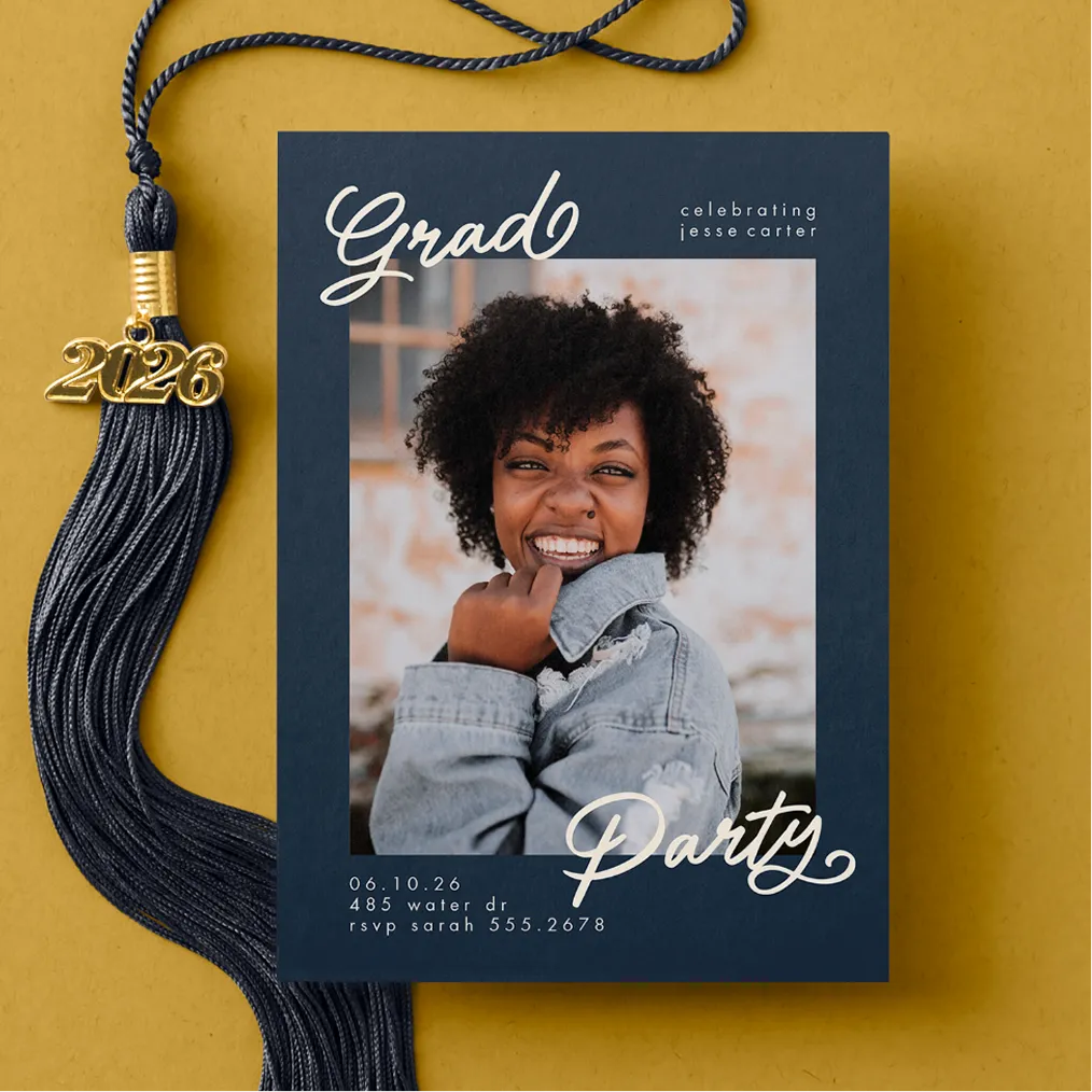 graduation invitation next to tassel on yellow background