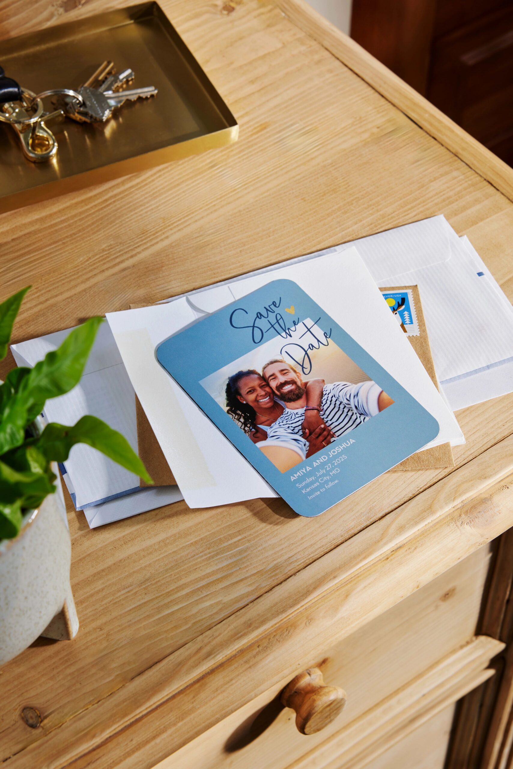 save the date magnet on top of a white envelope on a desk