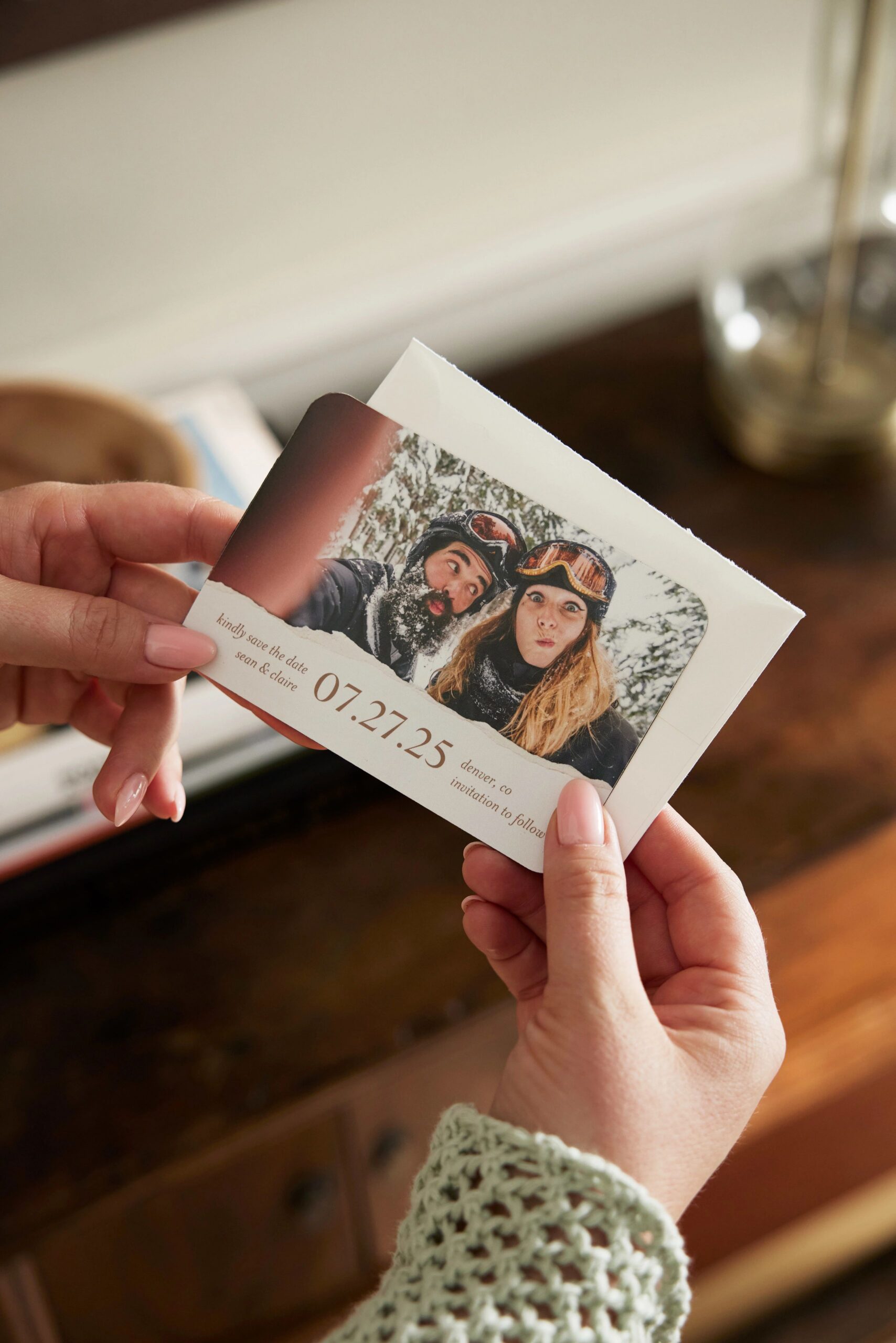 hands holding a save the date magnet
