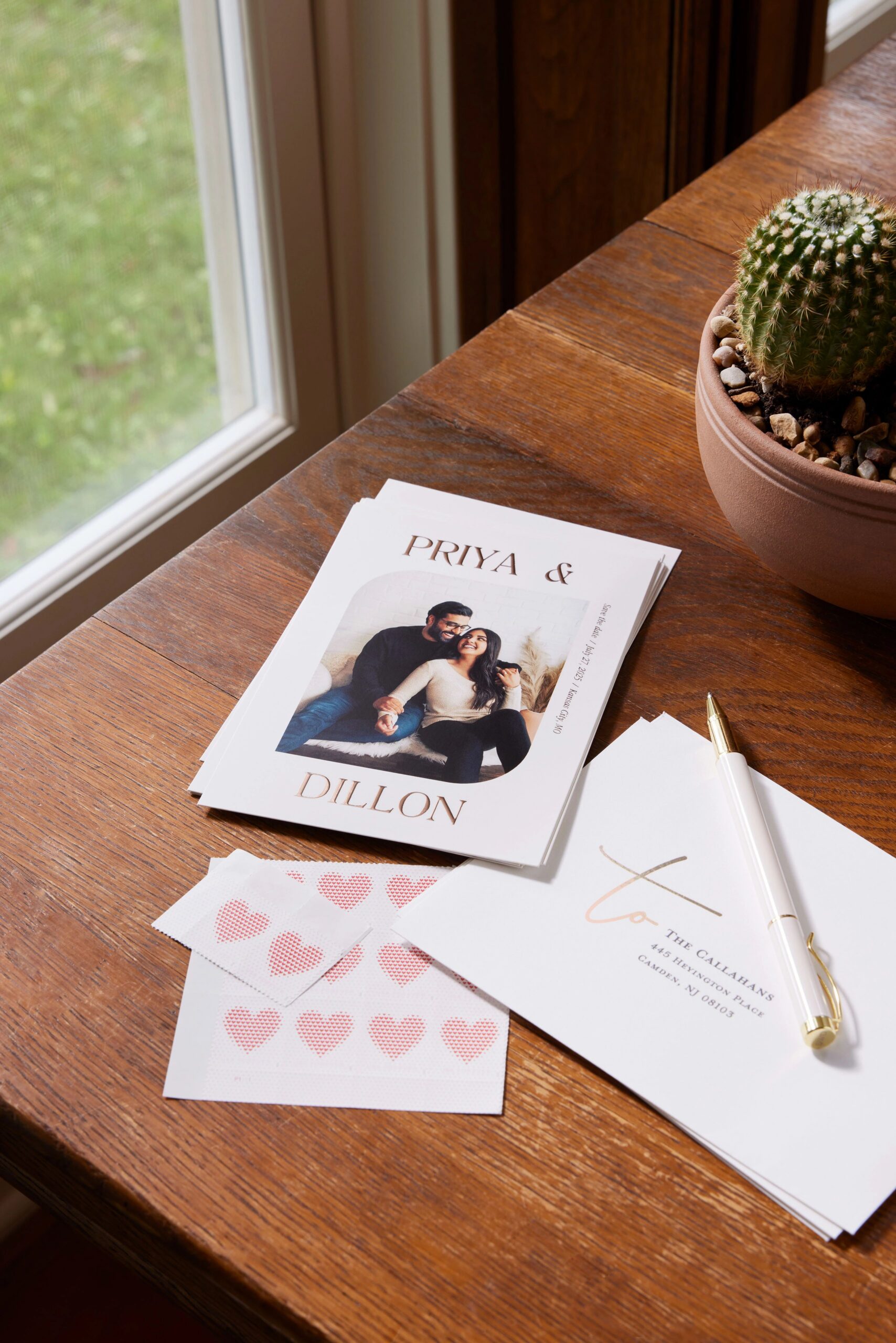 save the date card and addressed envelope on a desktop with stamps