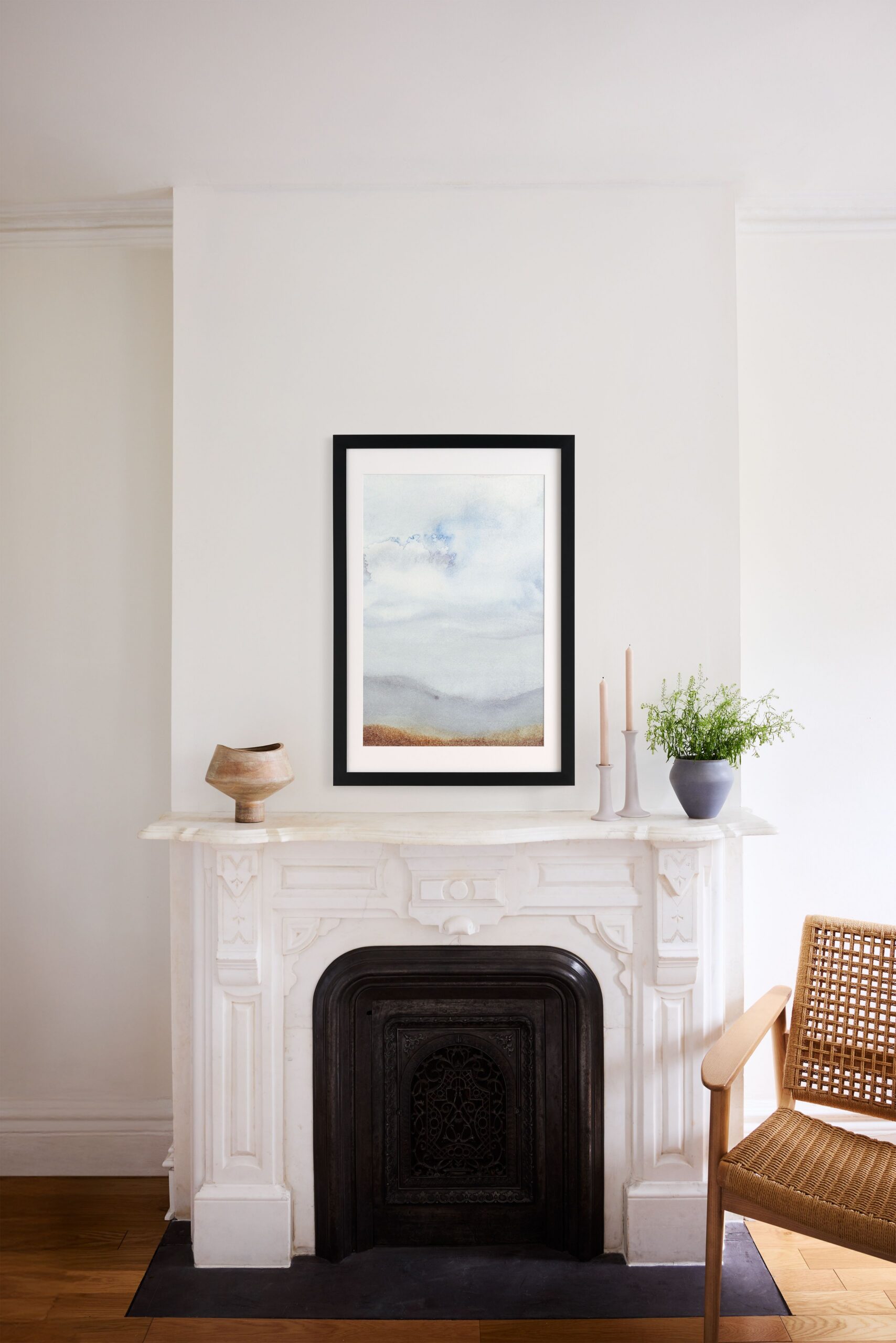 large black framed print above fireplace