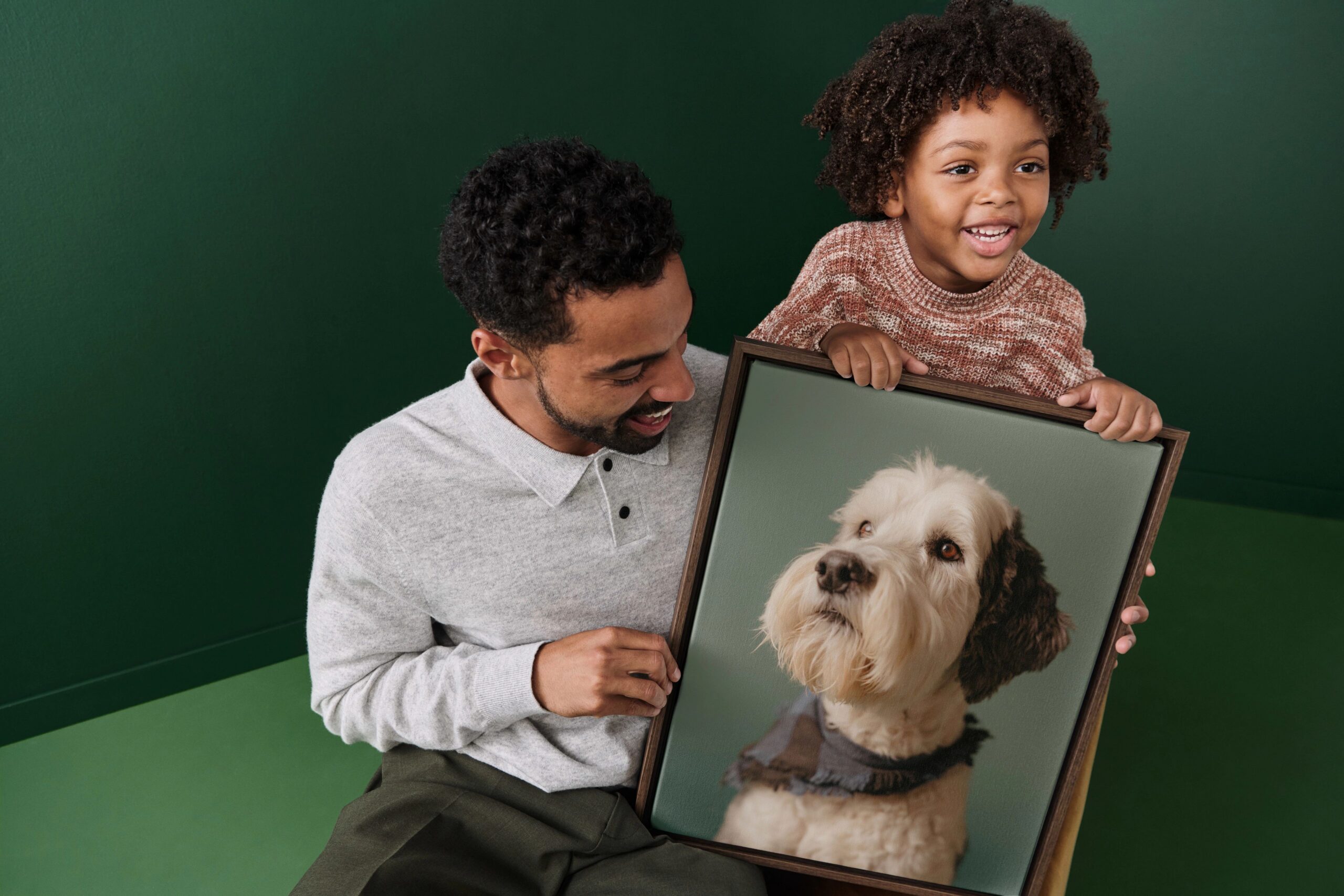 father and son holding a framed canvas print with a photo of a dog