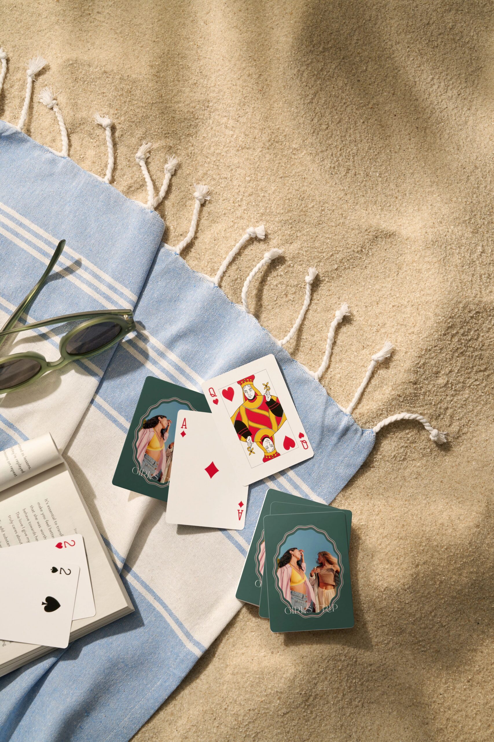 deck of personalized playing cards on a towel on sand