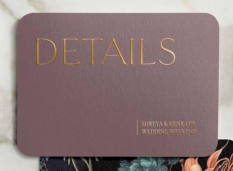 mauve enclosure cards that says details in gold foil